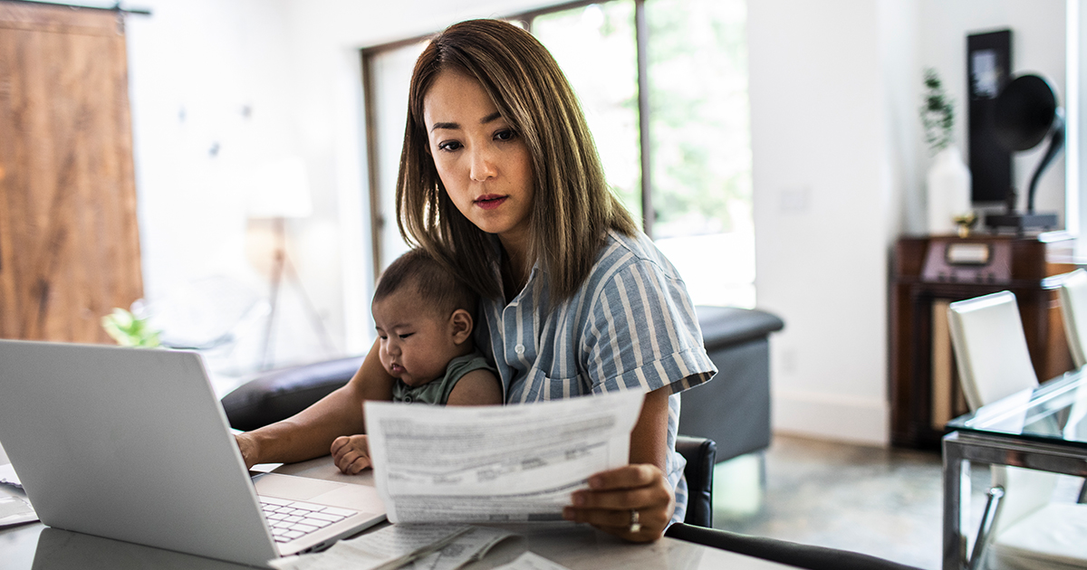 Woman working on computer with baby in lap